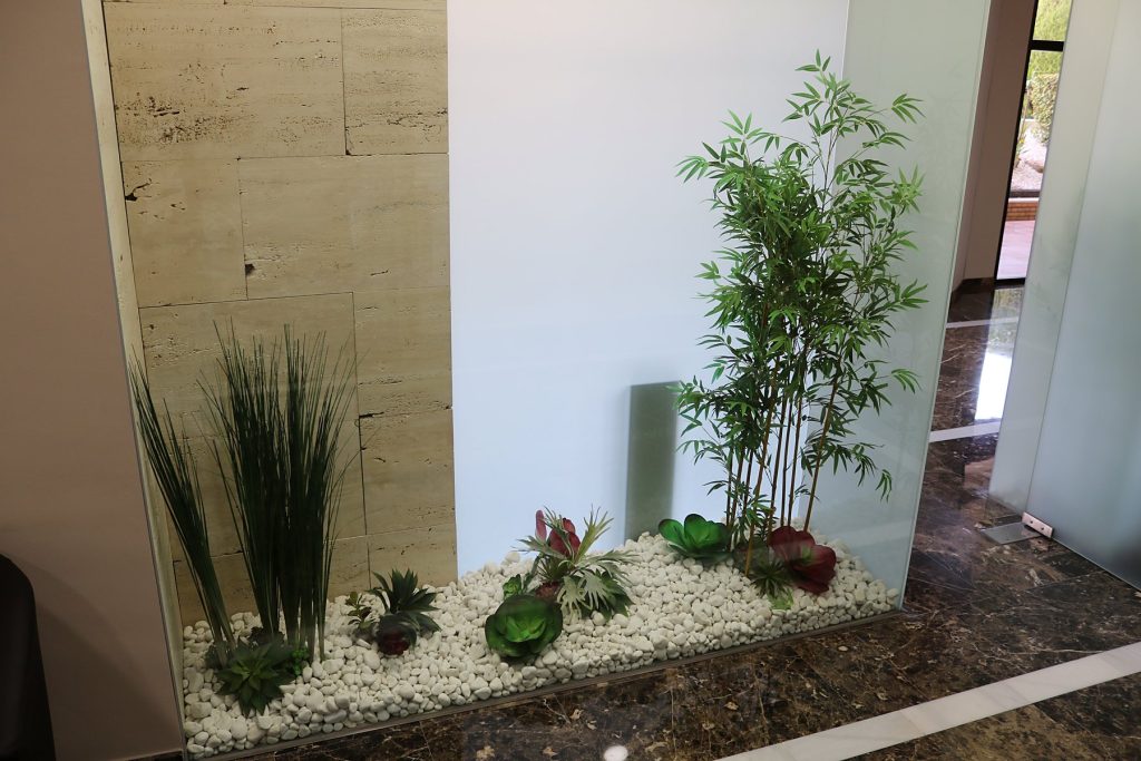 Pasillo interior con jardinera de gramíneas y bambú