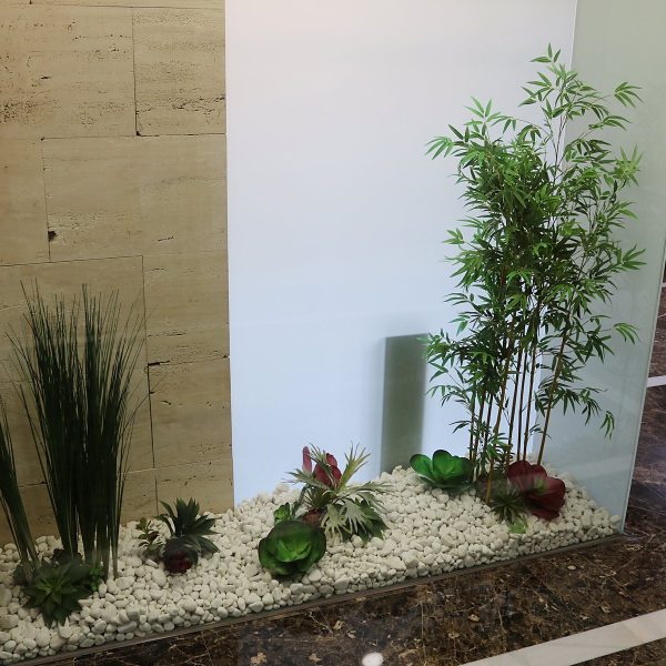 Pasillo interior con jardinera de gramíneas y bambú